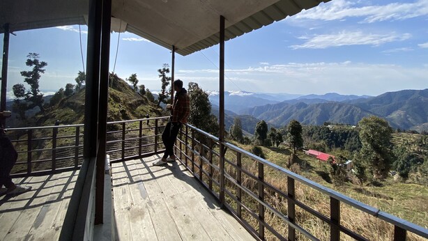 A wooden deck with a metal railing overlooking a mountainous landscape. - Life Resorts (Tehri)