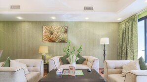 A hotel room with two sofas, a coffee table, a lamp, a painting, and a welcome sign. - OYO Home 300 2BHK Al Waleed Paradise JLT (Dubai)