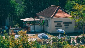 A villa with a tiled roof, outdoor seating, and a bar area. - Hotel Villa Strand (Hornbaek)