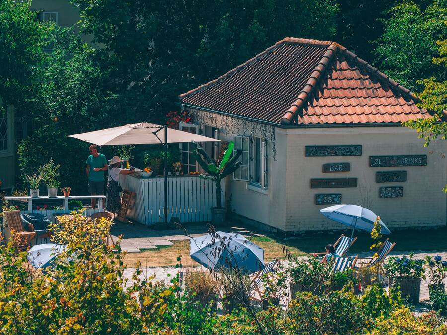 Una villa con techo de tejas, mobiliario exterior y una zona de bar.