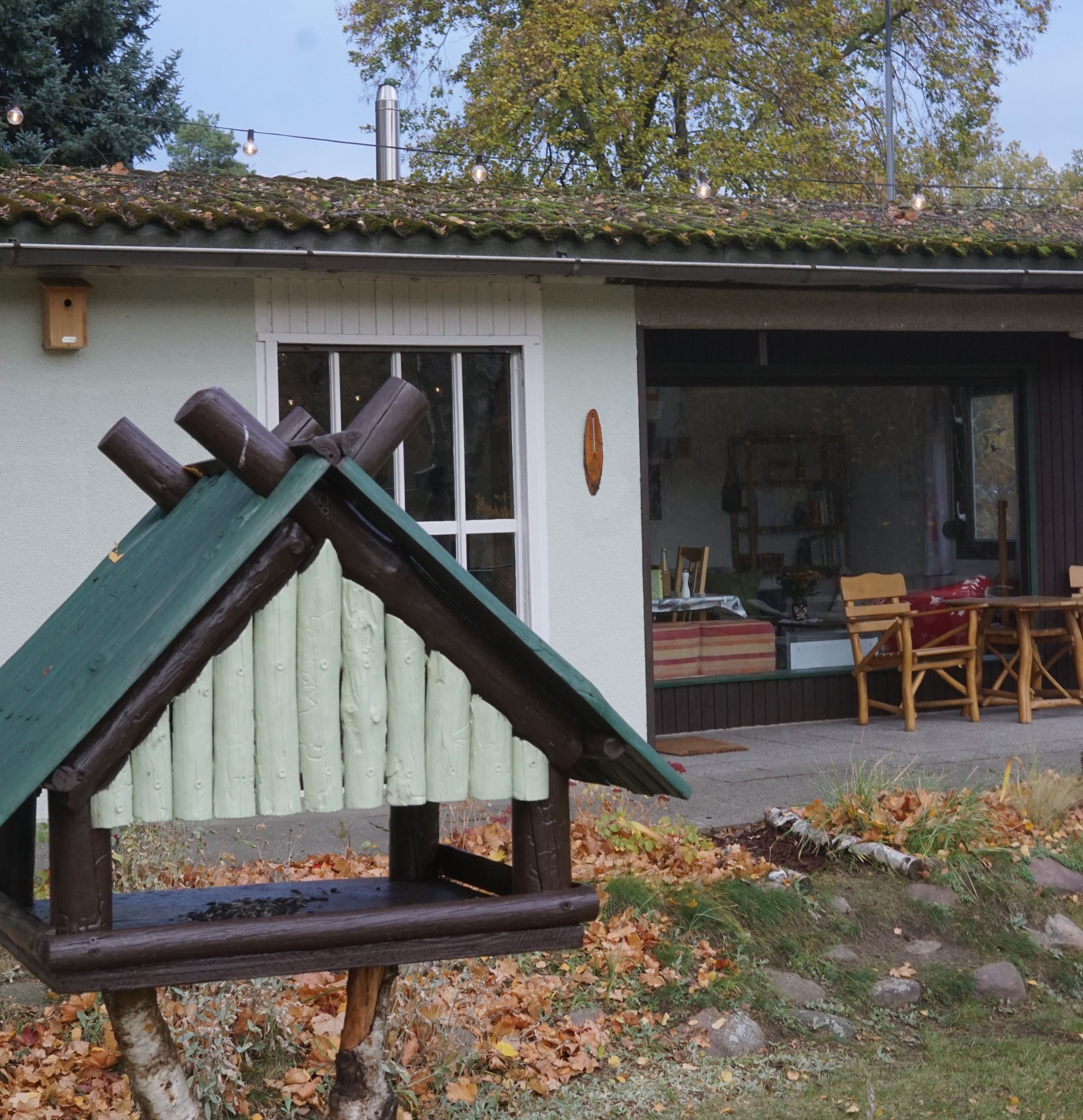Maalaishenkinen puinen rakennelma, jossa on kalteva katto, puinen aita ja ikkuna.