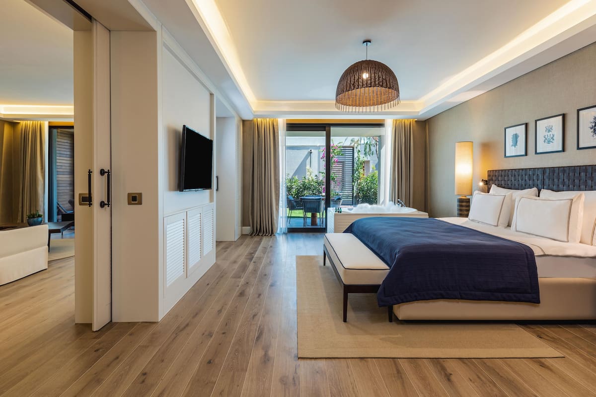 Une chambre d’hôtel moderne dotée d’un grand lit, d’une télévision et offrant une vue sur l’extérieur.