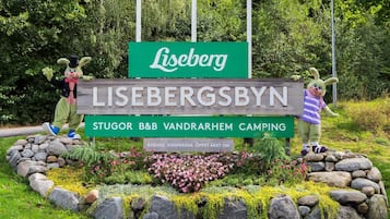 Welcome to Lisebergsbyn, a charming camping site surrounded by lush greenery and colorful flowers.