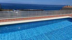 A clear blue pool with a view of the ocean and a building labeled "Puerto de la Cruz" in the background. - Central with sea views from the terrace. Pool and free wifi. (Puerto de la Cruz)