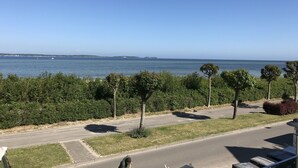 A view of a coastal road with trees and a clear blue sky. - Apartment Eltje on the 1st floor (Laboe)