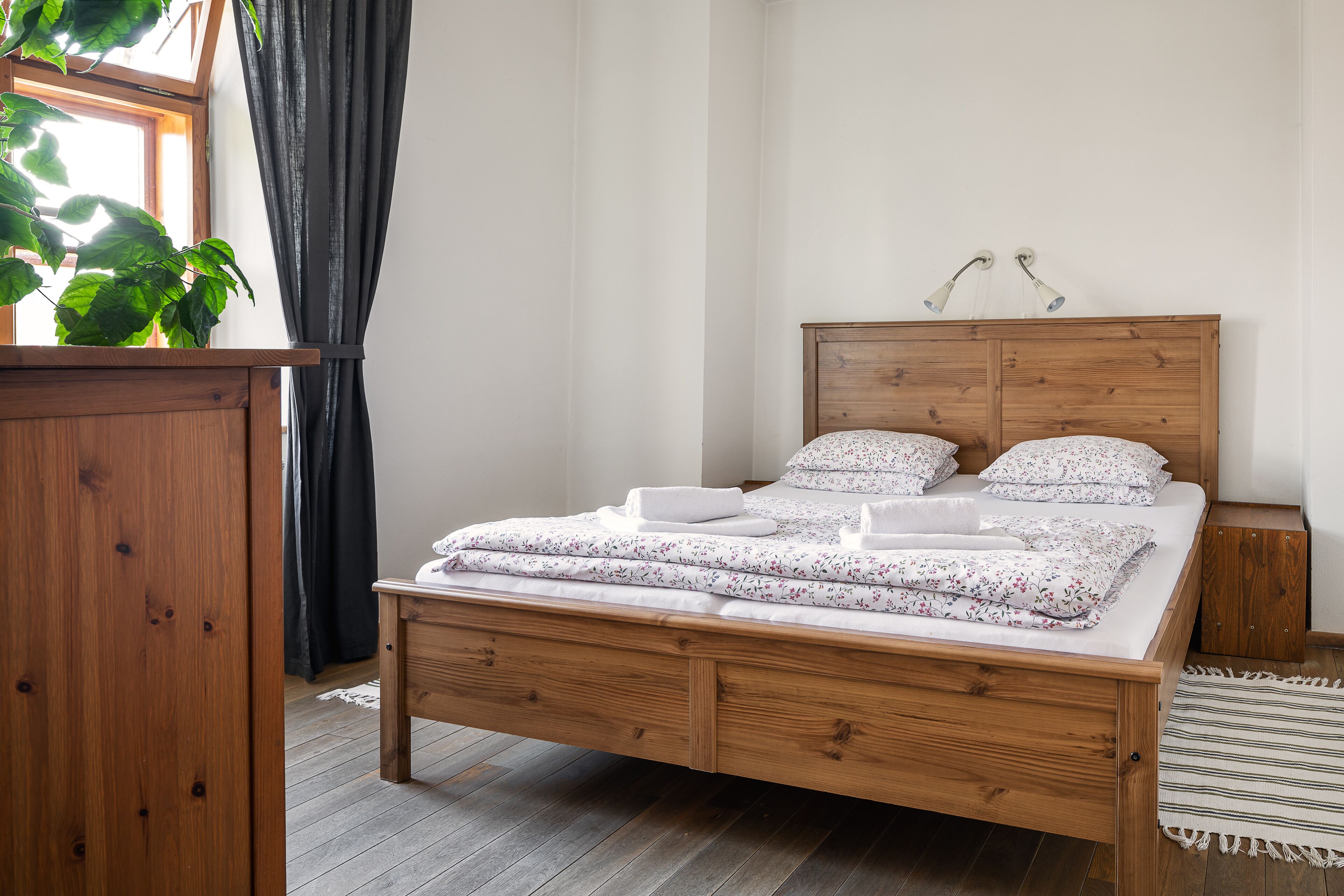 A wooden bed with a headboard, a bedside table, and a nightstand.