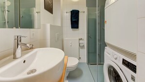 A modern bathroom with a sink, toilet, and washing machine. - Studio 4* center near Kirchberg, quiet with view (Luxembourg)