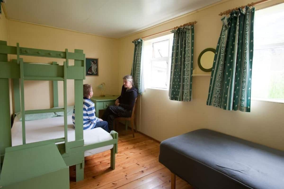 A room with bunk beds, a desk, and a single bed.