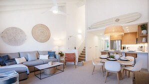 Un salon moderne avec un canapé, une table basse et un coin repas.