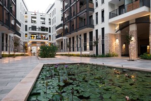 A modern building with multiple balconies, a central courtyard with a water feature, and stone accents. - Contemporary & Texture-Rich Hideaway (Tel Aviv)