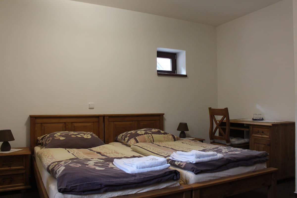 Ein Schlafzimmer mit einem Bett, zwei Nachttischen, einem Schreibtisch und einem Stuhl.
