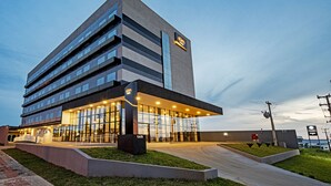 A modern hotel building with a flat facade, large windows, and a prominent entrance area. - Slim Guarapuava (Guarapuava)