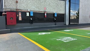 A parking area with green bike lanes and electric vehicle charging stations. - Slim Guarapuava (Guarapuava)