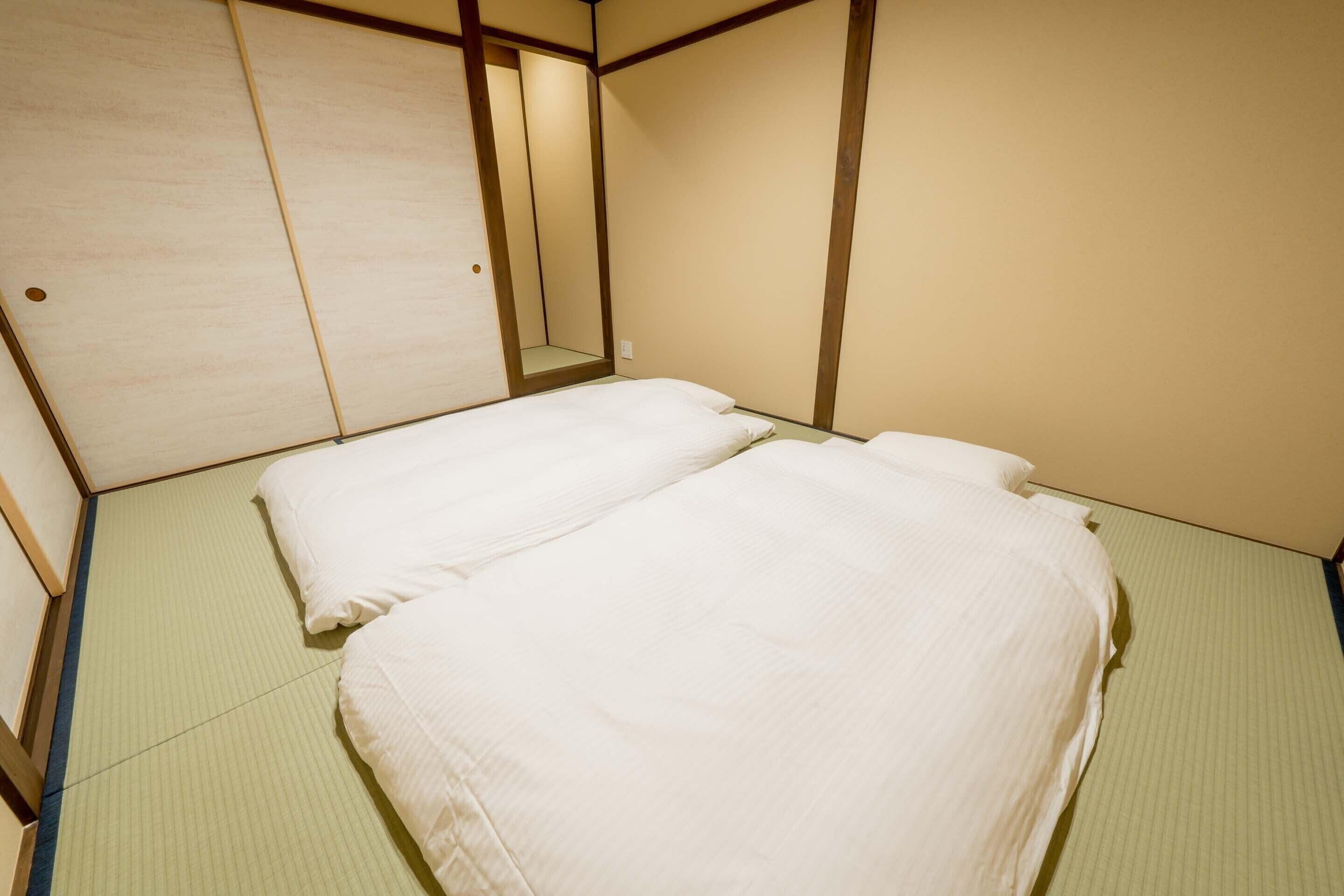 A room with a bed, a mirror, and a wooden sliding door.