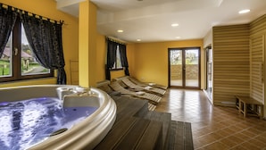 A spa area with a hot tub, seating, and a view of the outdoors.