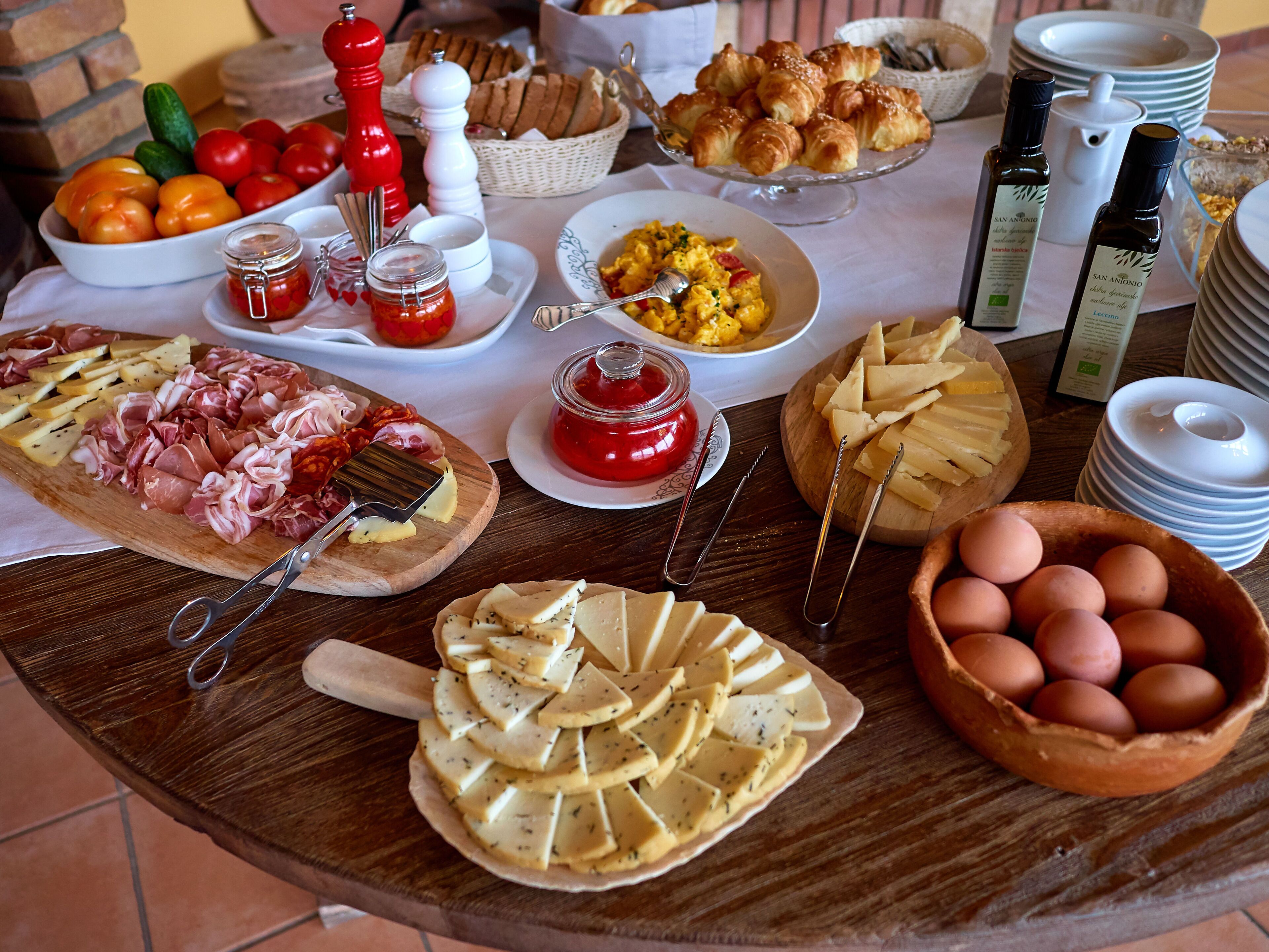 Ein reichhaltiges Frühstücksbuffet mit verschiedenen Speisen, darunter Käse, Eier und Gebäck.