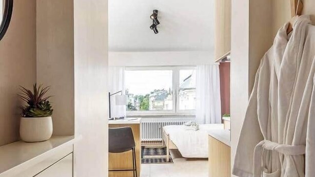 Una habitación de hotel moderna con baño, zona de estar y vistas.