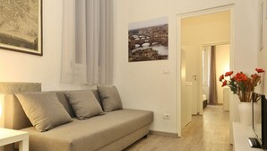 Ein modernes Wohnzimmer mit einer Couch, einem Gemälde und einem gerahmten Bild an der Wand.