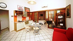 A compact living space with a kitchen, dining area, and a red sofa.