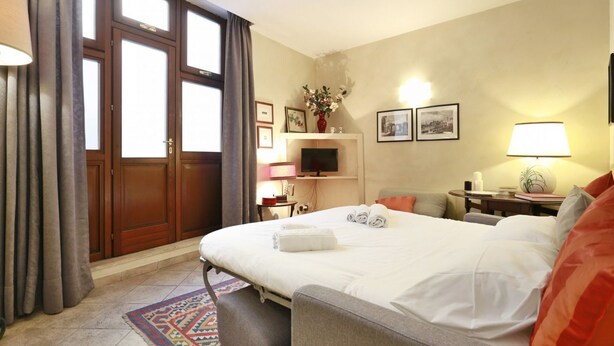 Una habitación de hotel con una cama grande, un sofá, un televisor y una chimenea.