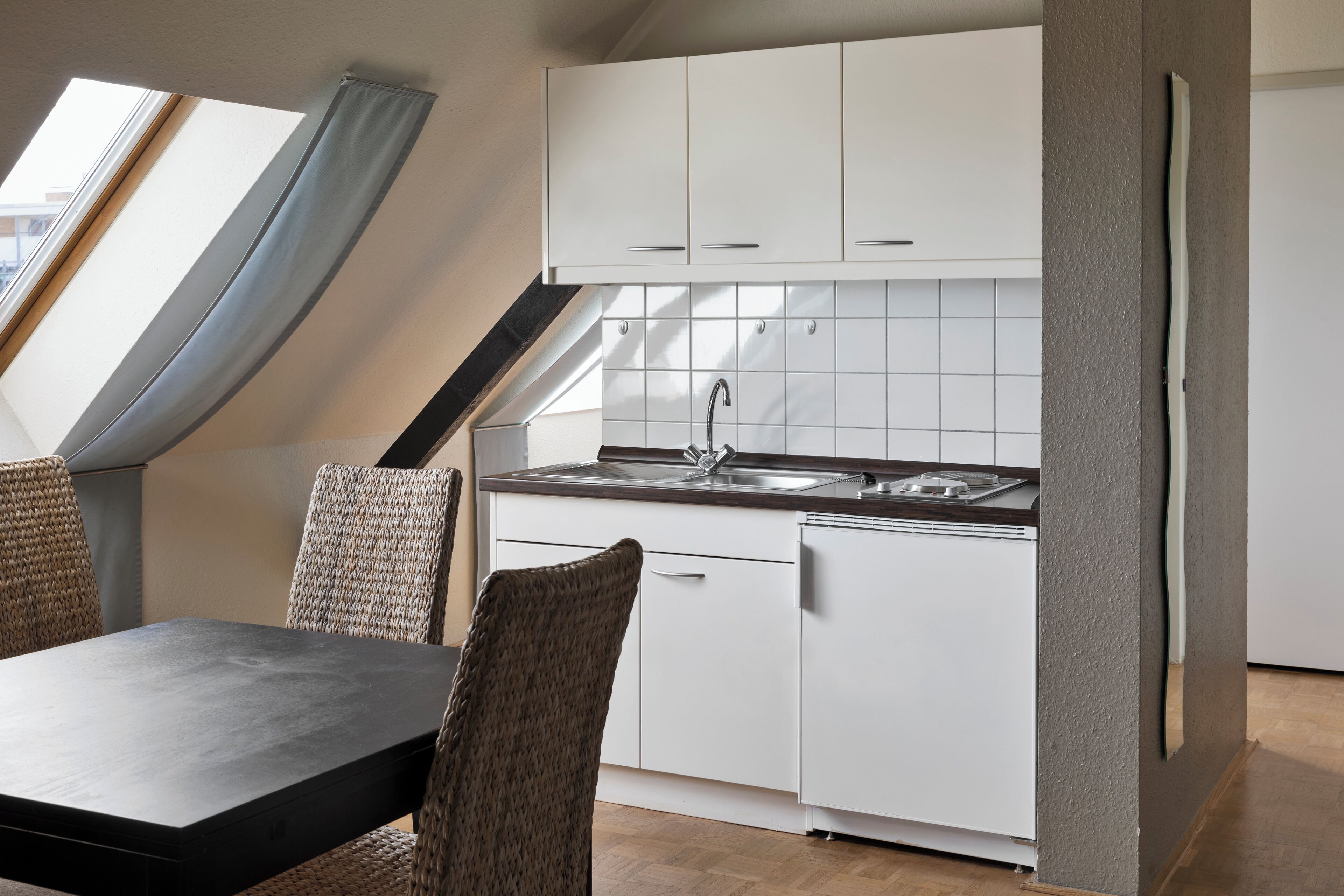 A modern kitchen with white cabinets, a built-in oven, and a sink.