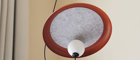 A pendant light with a circular shade and a white bulb, hanging from a cord.