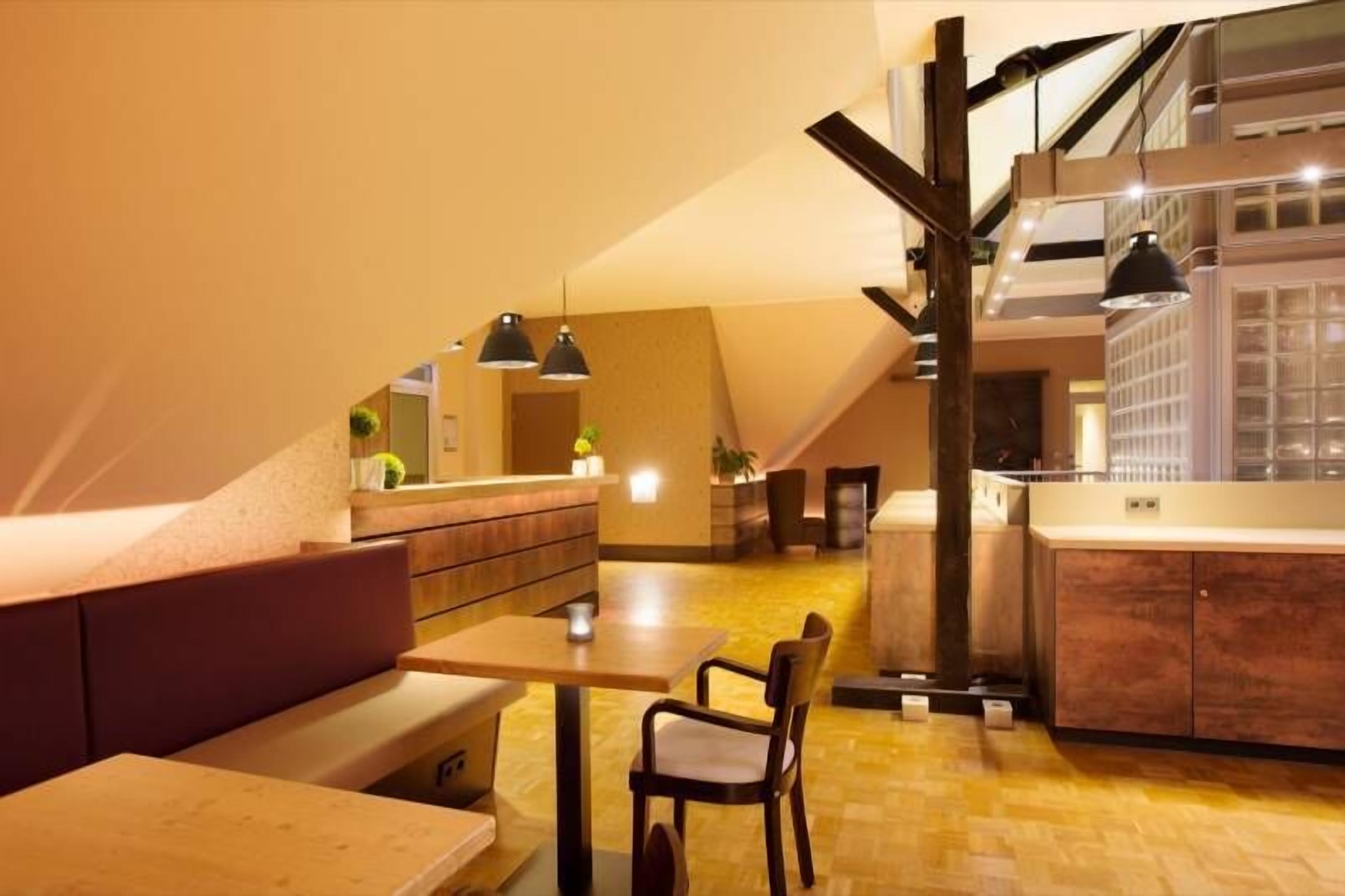 Un intérieur moderne comprenant un coin repas, une cuisine et un escalier.