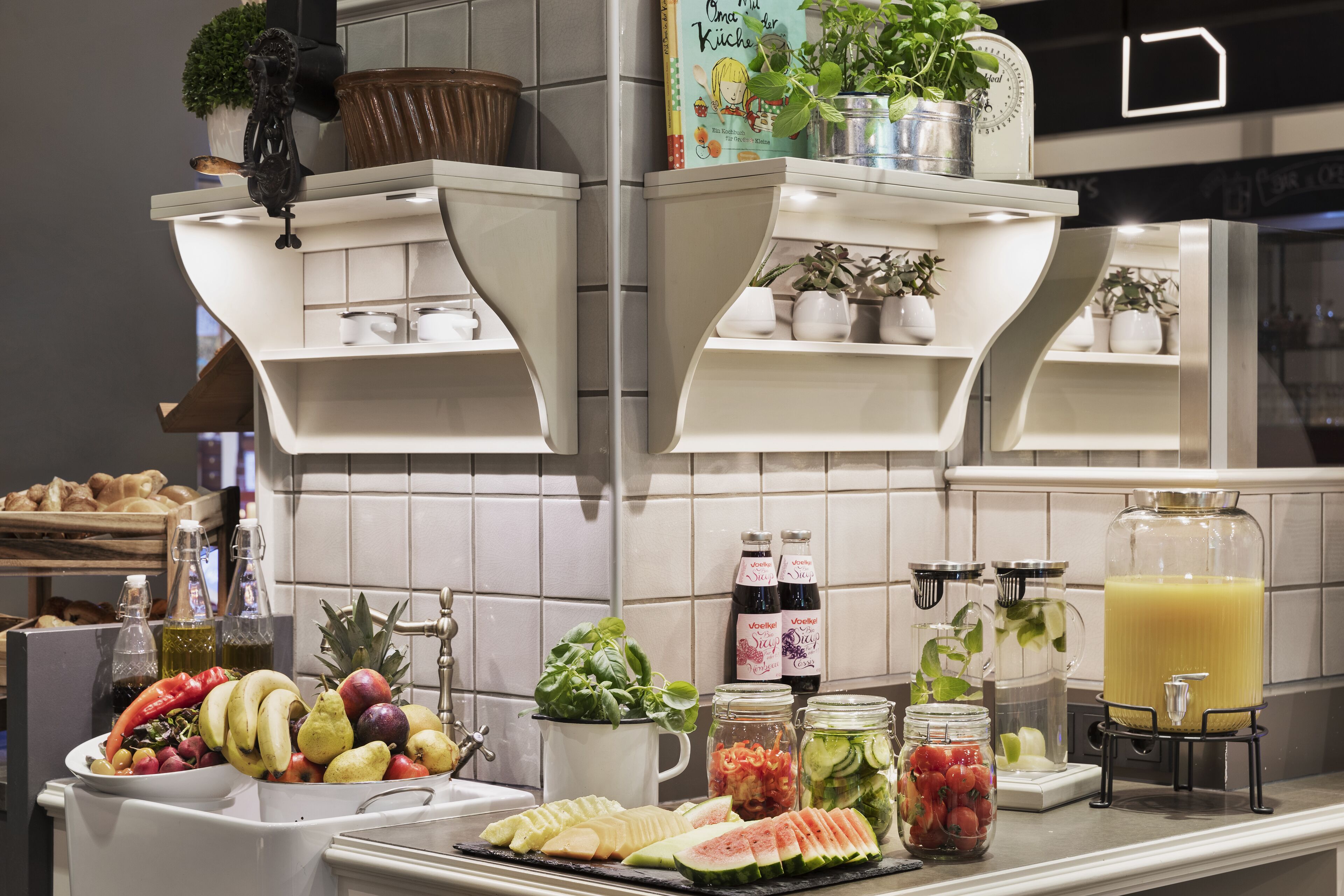 Ein Frühstücksbuffet mit verschiedenen Früchten, Gemüsesorten und Getränken.