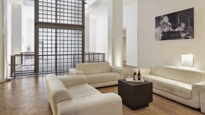 Un salón amplio con un gran ventanal, una mesa de centro negra y un sofá beige.