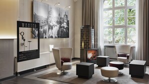 Una sala de estar moderna con chimenea, asientos cómodos y obras de arte en las paredes.