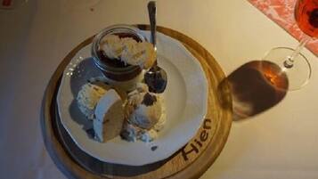 A dessert plate with ice cream and a spoon, placed on a wooden board with the name "Hien" on it.