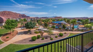 A resort with multiple buildings, a swimming pool, and a mountainous backdrop. - Steps to Pool | Lazy River | Waterslide | Poolside Villa | Arcadia #9 (Santa Clara)