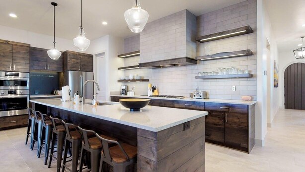 A modern kitchen with a large island, bar stools, stainless steel appliances, and a brick backsplash. - Steps to Pool | Lazy River | Waterslide | Poolside Villa | Arcadia #9 (Santa Clara)