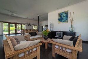 A modern living room with a sofa set, a coffee table, a TV, and a painting on the wall.