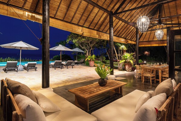 An outdoor lounge area with a pool, seating, and dining space.