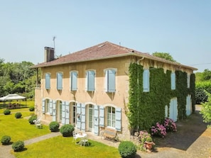 A two-story building with a garden in front.