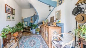 A cozy interior with a spiral staircase, wooden furniture, and various decorative items.