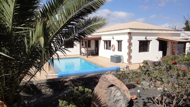 Zona de piscina amb una casa al fons.