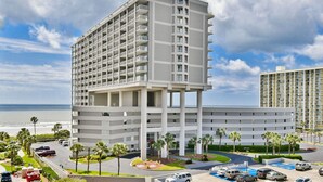 Un hôtel à plusieurs étages doté d’un atrium central, d’un parking et offrant une vue sur l’océan.