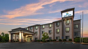 A multi-story hotel with a prominent Bay Inn sign, a covered entrance, and a parking lot. - Bay Inn & Suites Troy (Troy)