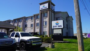 A Bay Inn hotel with a sign, a parking lot, and a grassy area. - Bay Inn & Suites Troy (Troy)