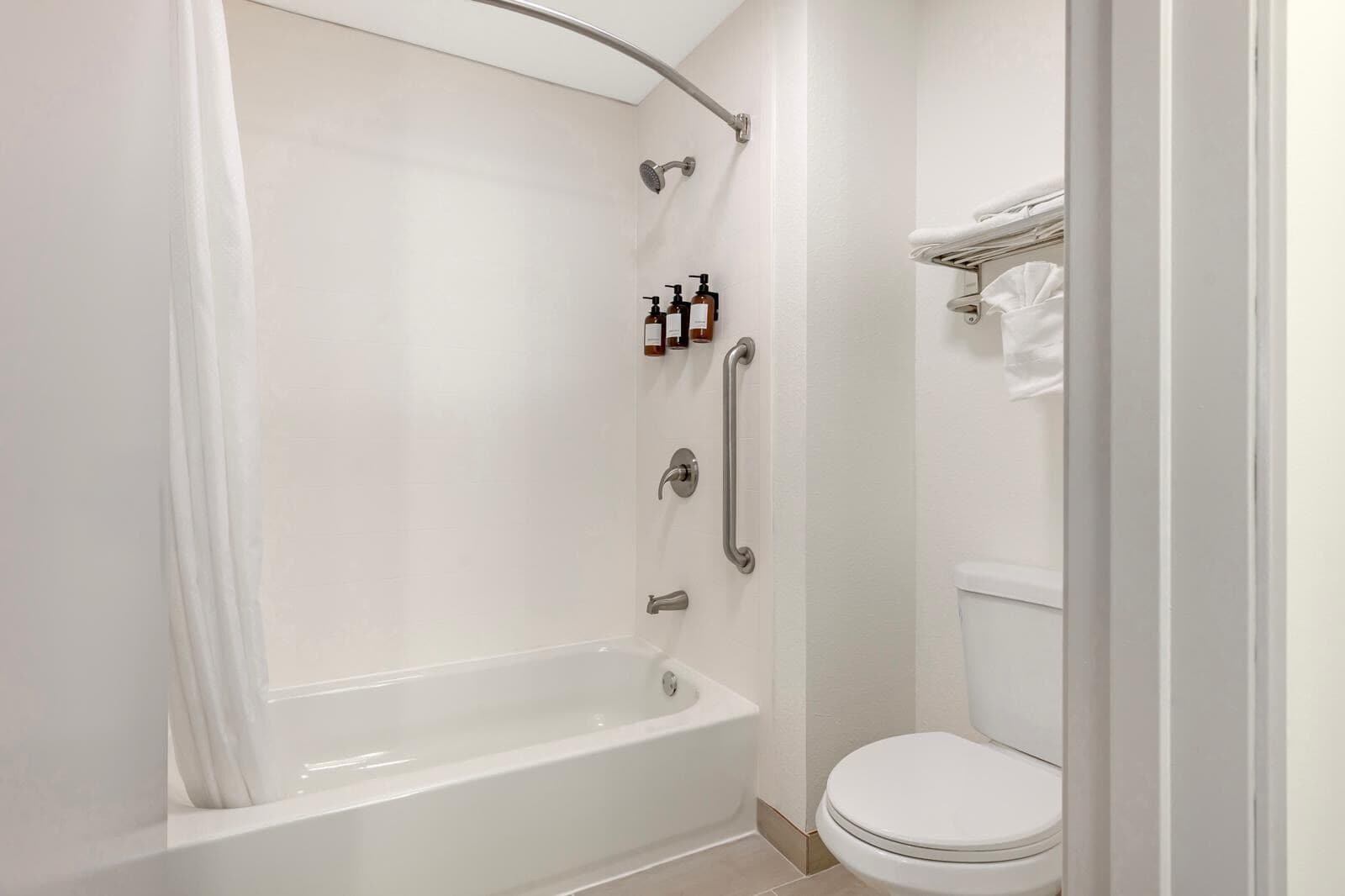 A bathroom with a bathtub, a toilet, and a shower area.