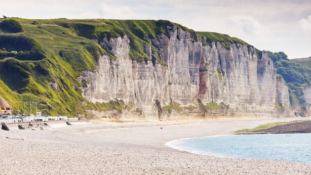 Eine Küstenlandschaft mit Sandstrand und hohen Klippen.