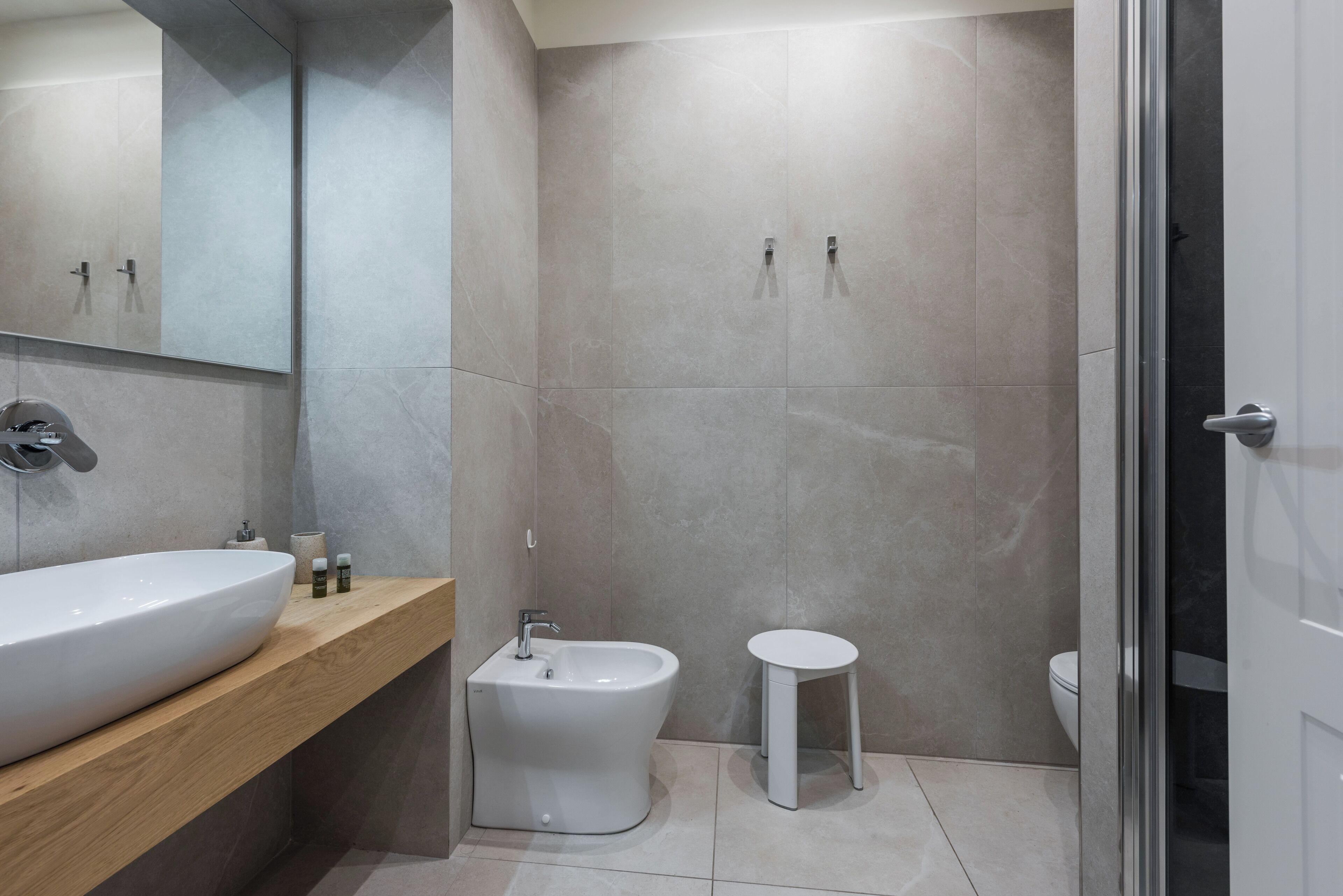 Un baño moderno con un lavamanos grande, un bidé y un inodoro.