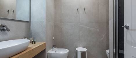 Un baño moderno con un lavamanos grande, un bidé y un inodoro.