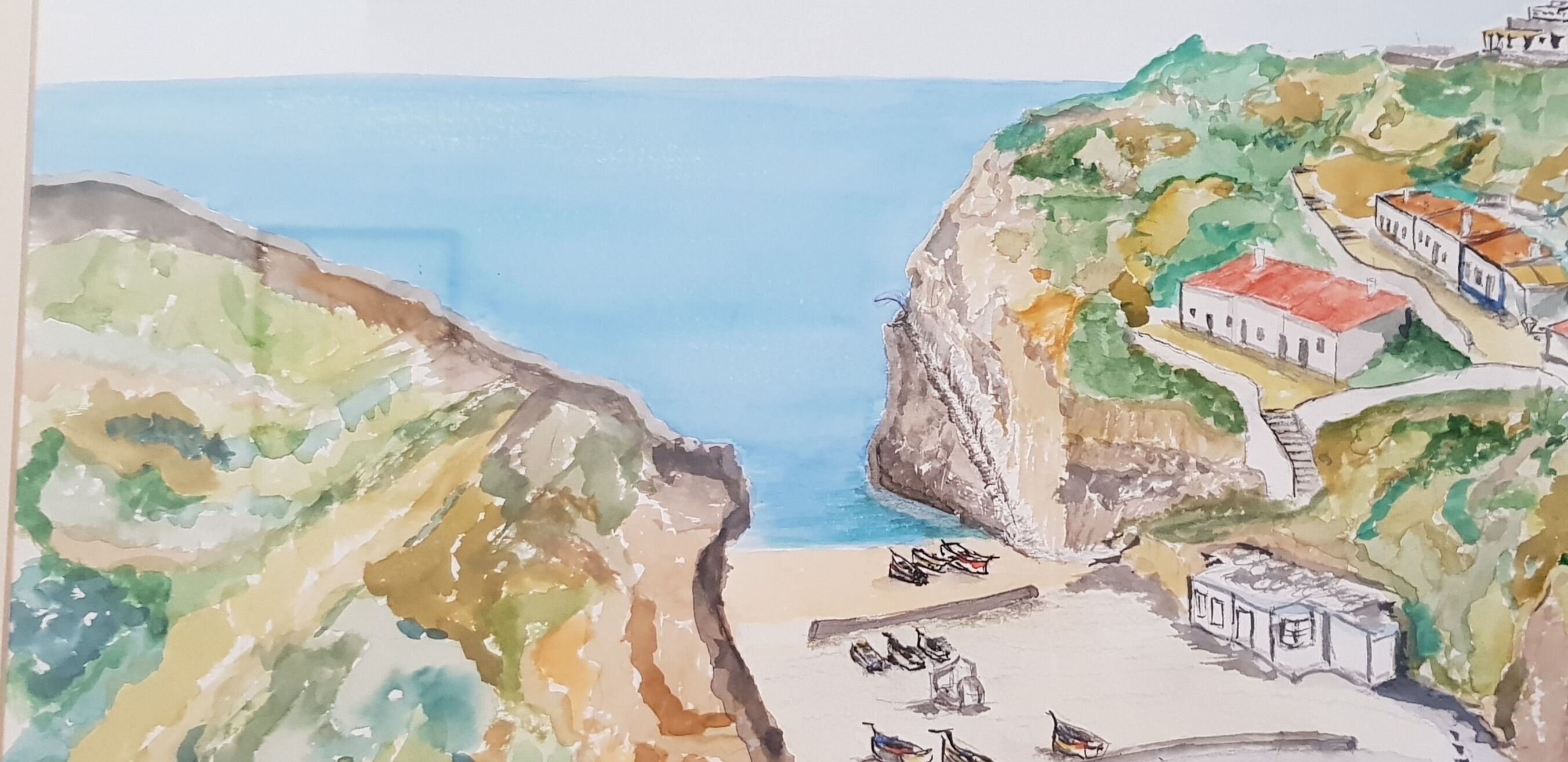 Un paysage côtier avec des falaises, une plage et des bâtiments.