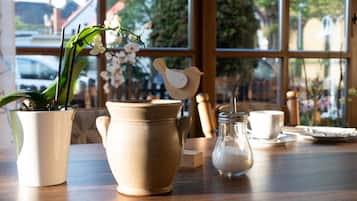 Une table avec un pot en céramique, un bocal en verre et une tasse en céramique.