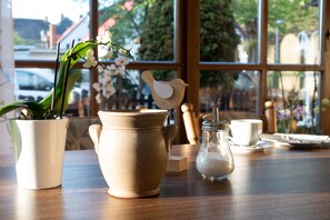 Ein Tisch mit einem Keramiktopf, einem Glasbehälter und einer Tasse.