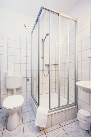 Een douche, handdoeken, toiletpapier