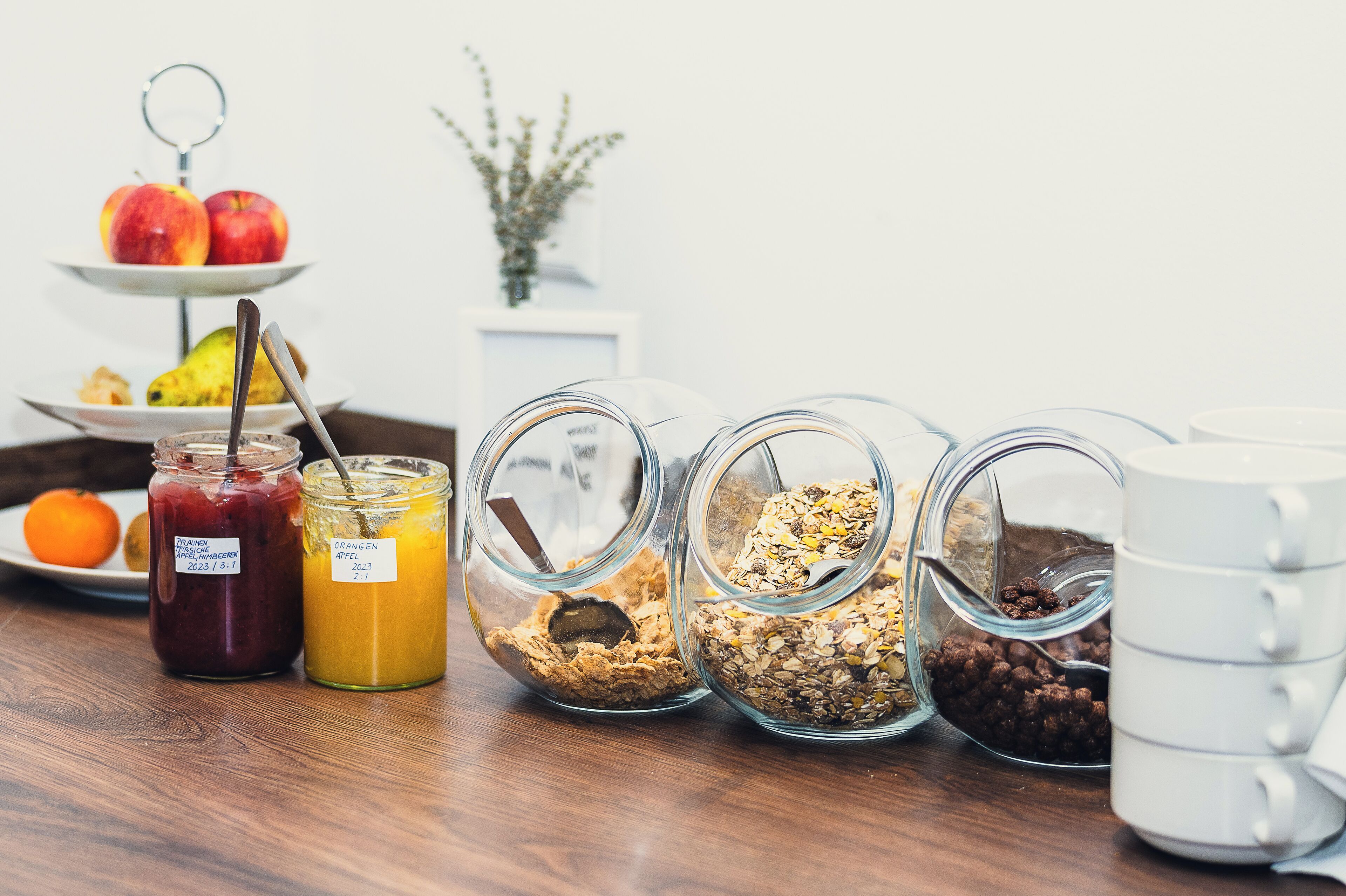A breakfast setup with various food items and a white mug on a wooden table.